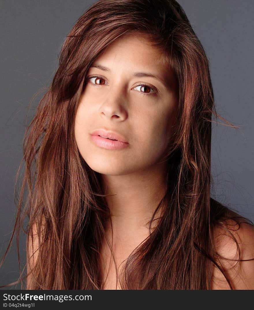 A portrait of a pretty young woman with messy hair, staring at the viewer