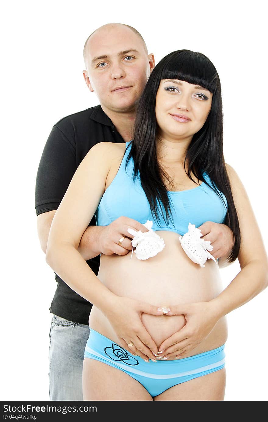 Happy pregnant couple with baby shoes