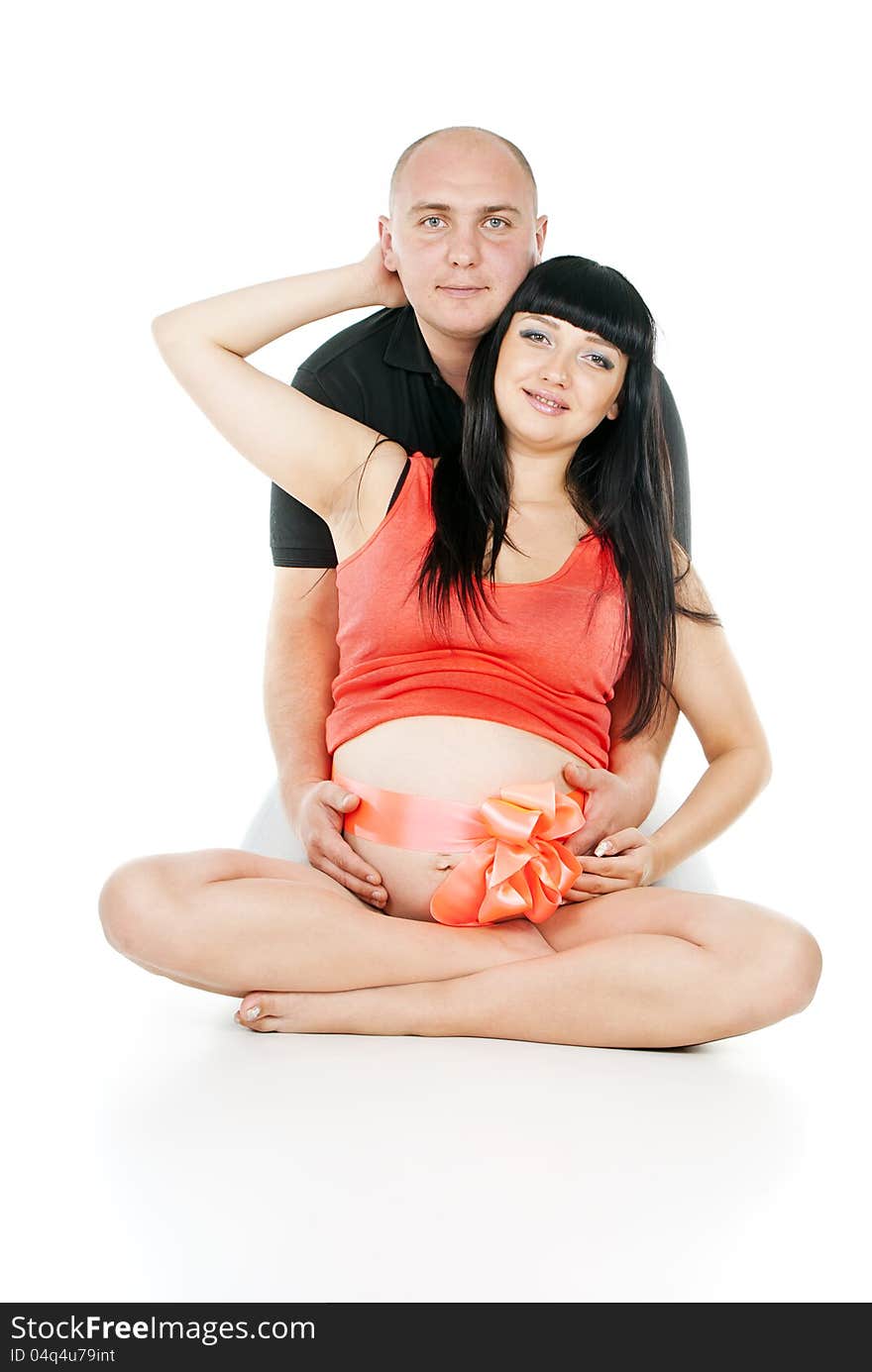 Happy pregnant couple with a bow on her stomach