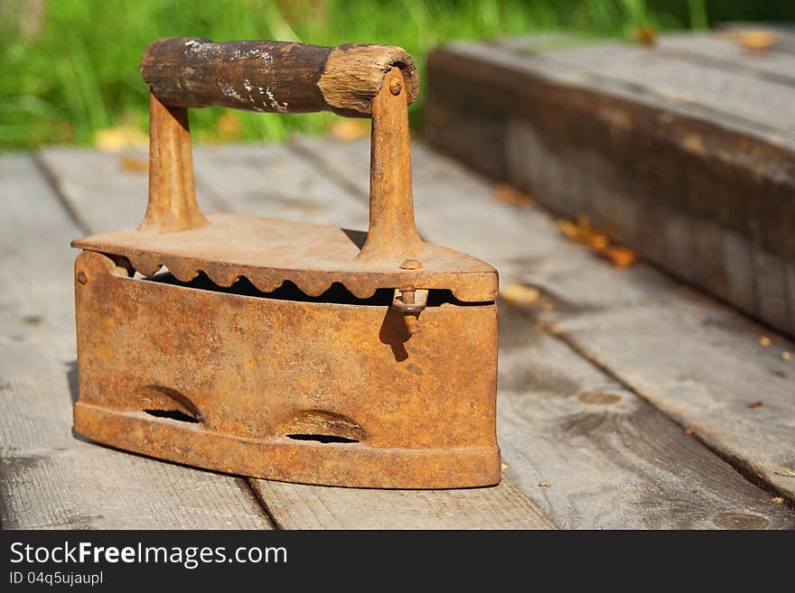 Old coal iron, standing on a wooden sidewalk. Old coal iron, standing on a wooden sidewalk