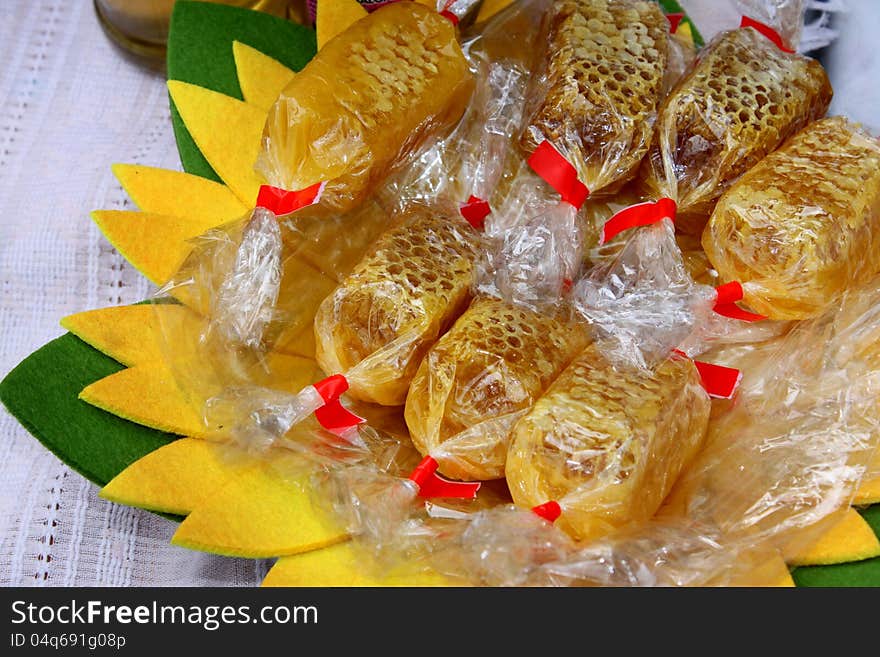 Honey comb wrapped in cellophane exposed on the yellow plate. Honey comb wrapped in cellophane exposed on the yellow plate.