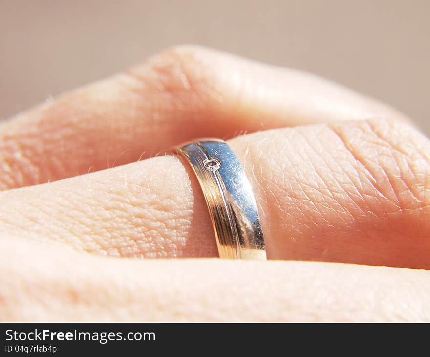 White and yellow gold ring, with a diamond, on male finger