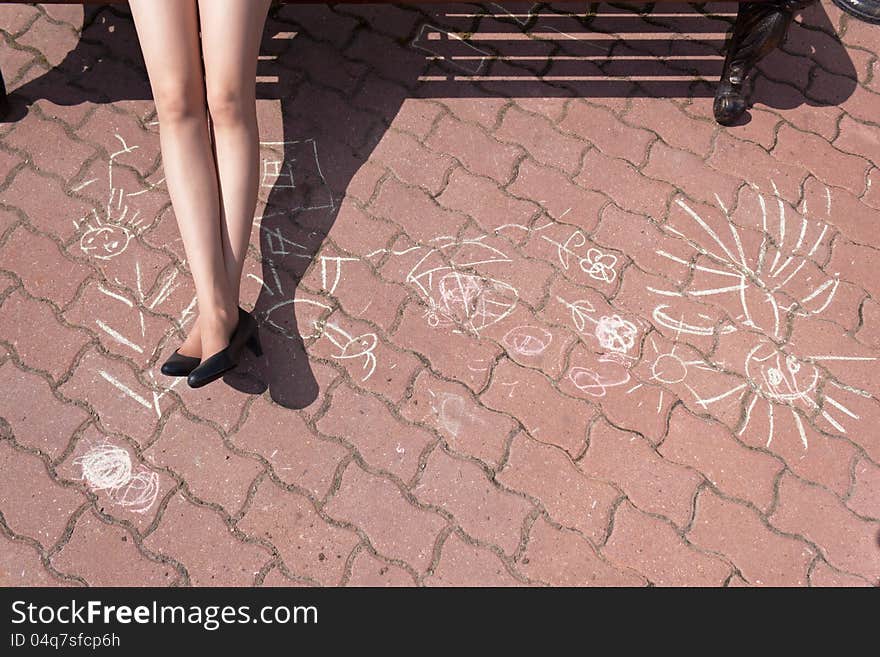 Feet Of The Young Girl Against Drawing A Chalk