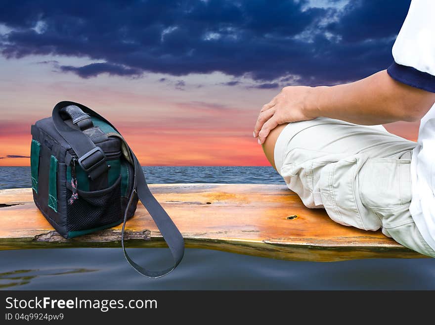 Thai man relaxing by sitting on the bags, which are not close to the water and clouds in the background. Thai man relaxing by sitting on the bags, which are not close to the water and clouds in the background.