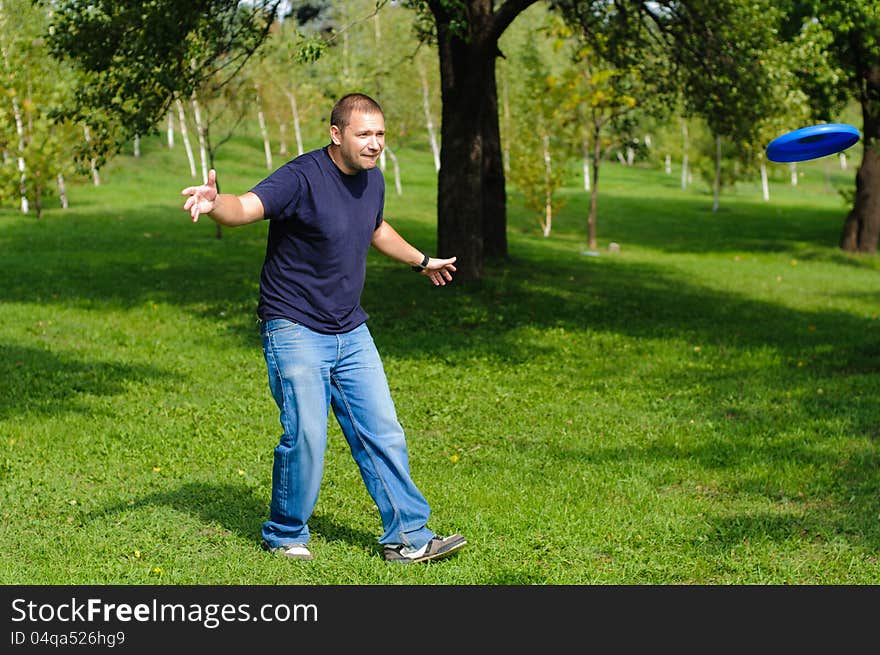 Young man playing frisbee on green grass