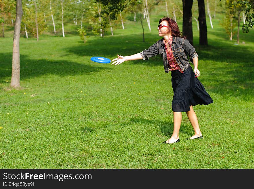 Young woman having fun with frisbee in the parkin sunny summer day. Young woman having fun with frisbee in the parkin sunny summer day.