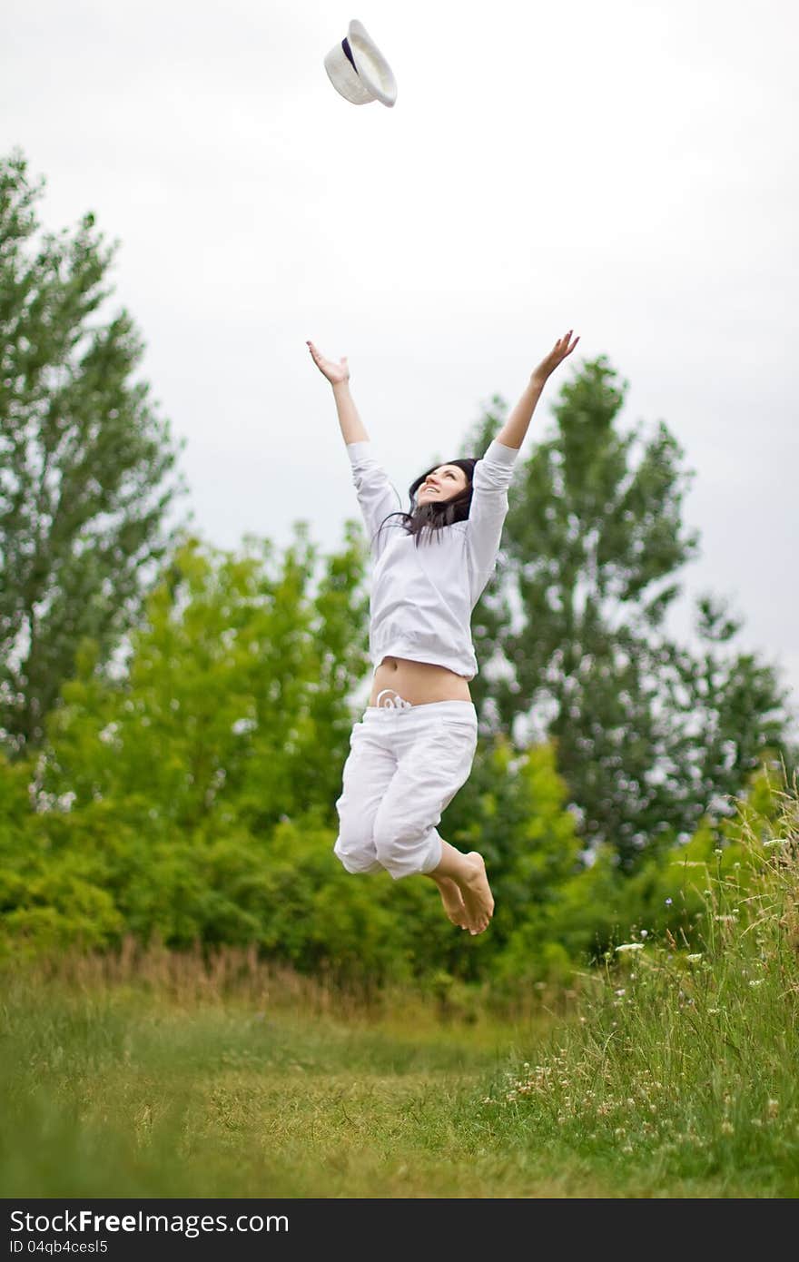 Beautiful woman throw her hat and jump. Beautiful woman throw her hat and jump