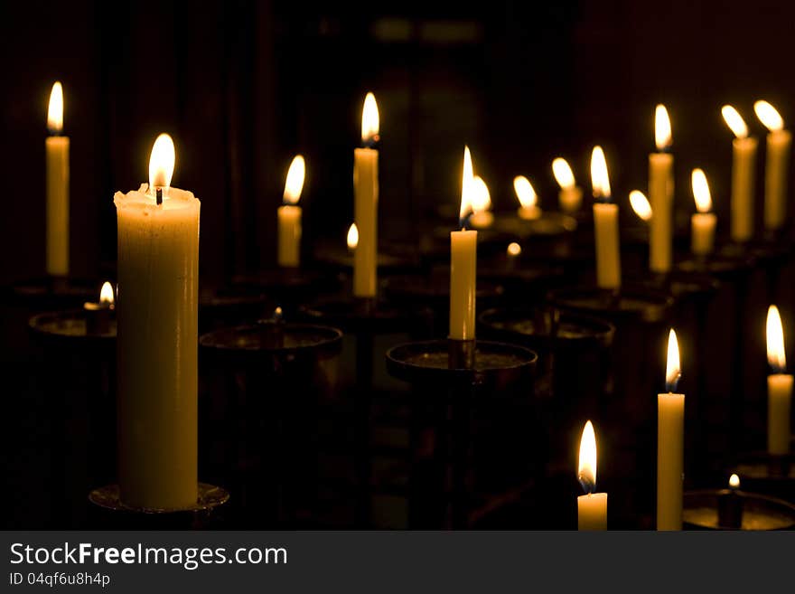 Many candles burning at a dim church. Many candles burning at a dim church.