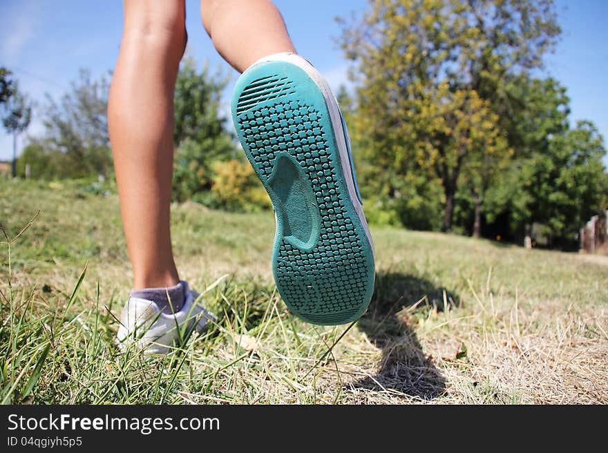 A young girl enjoys running on the green grass. A young girl enjoys running on the green grass