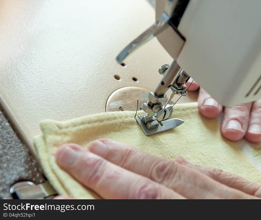 An elderly woman sew on a typewriter