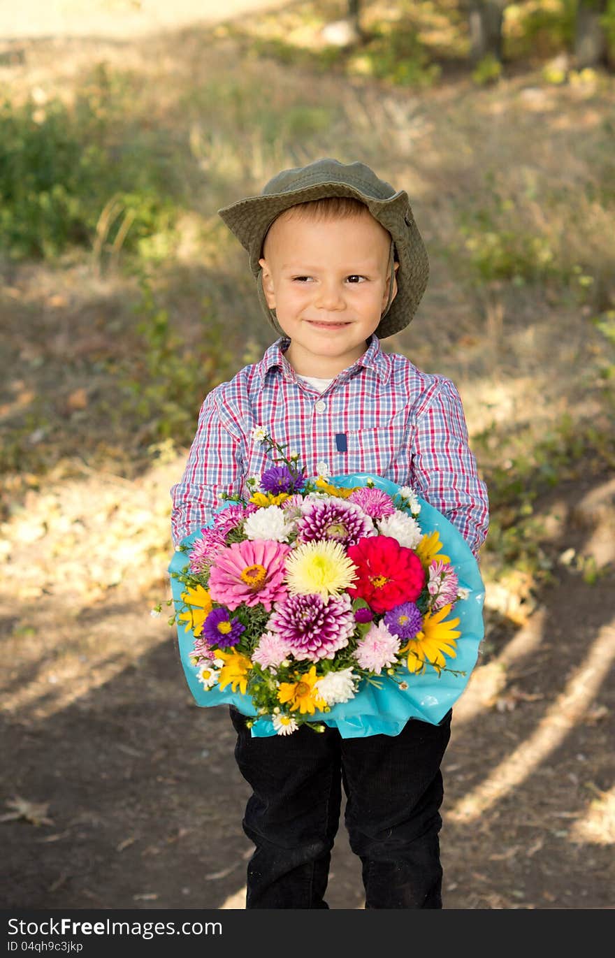 Smiling young boy holding flowers