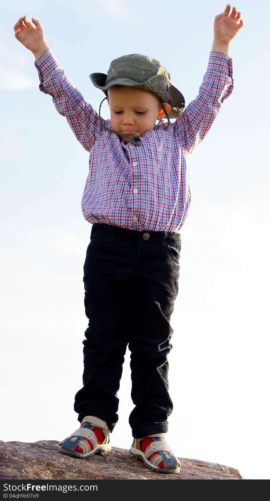 Little boy balanced on a rock