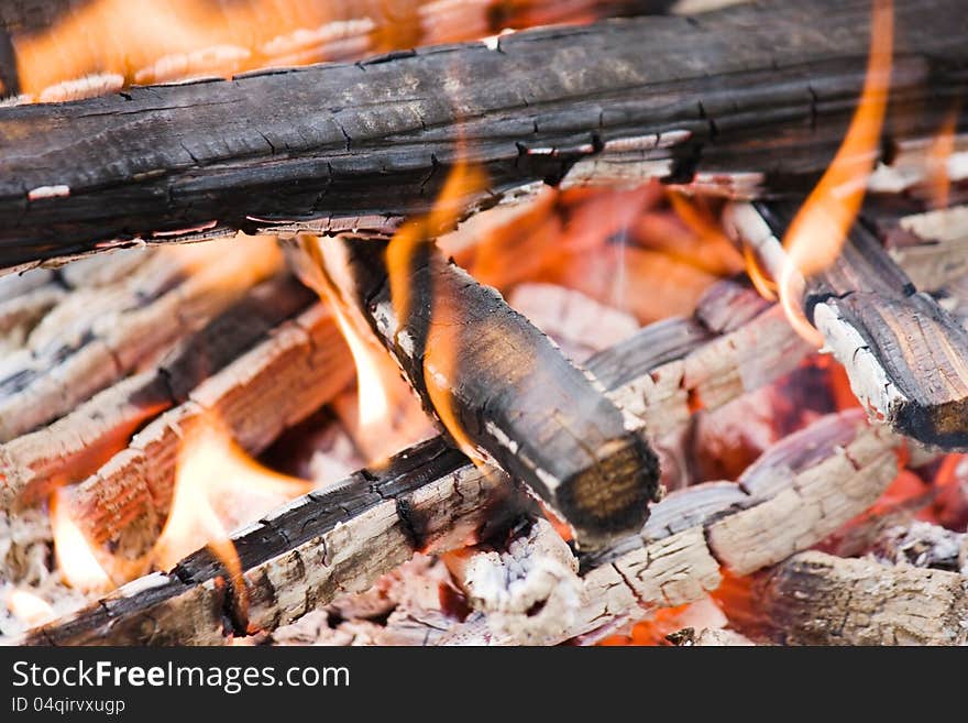 Camping bonfire with flame, firewood and calx fragment close-up view. Camping bonfire with flame, firewood and calx fragment close-up view