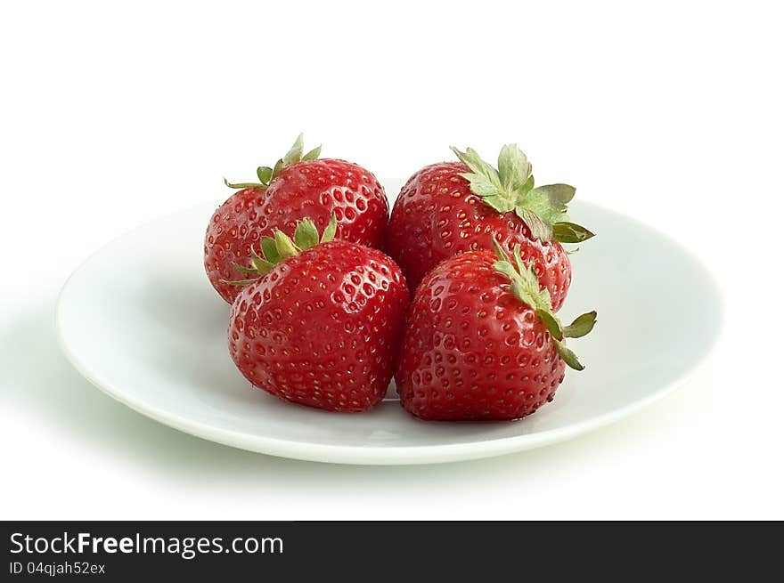 Four strawberries on a white saucer with white background