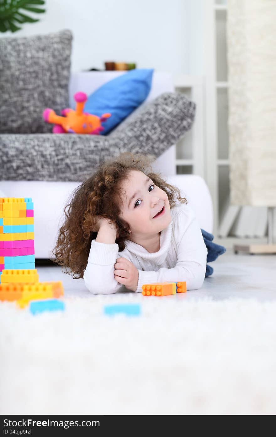 Cute little girl lying n floor with her toys. Cute little girl lying n floor with her toys