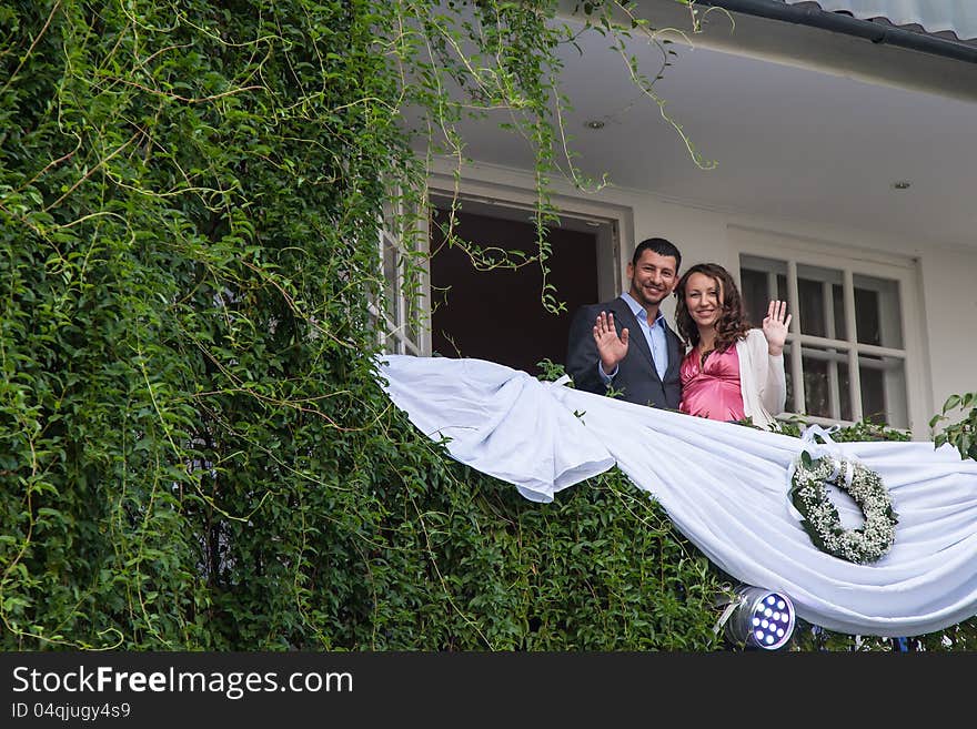 Young couple on balcony of his new home