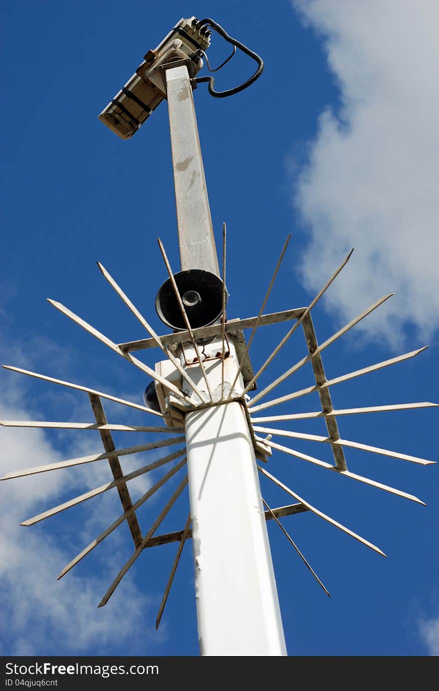 Street security camera against a blue sky from below. Street security camera against a blue sky from below.