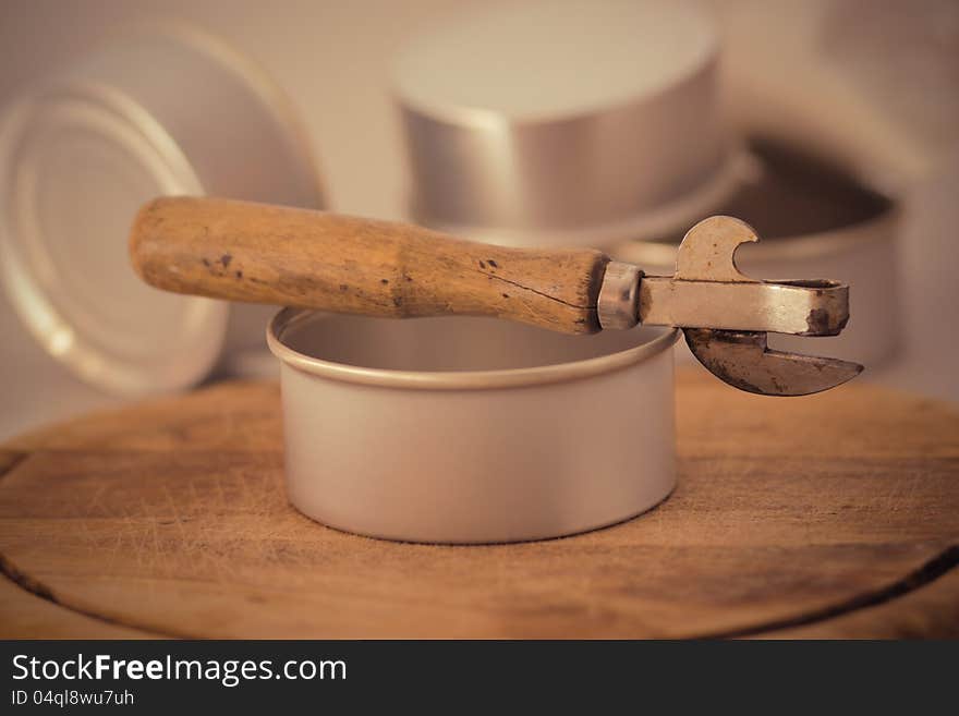 An old opener surrounded by tins. An old opener surrounded by tins