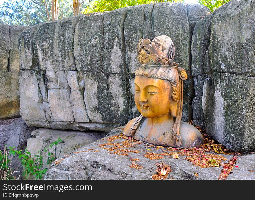 A statue of an Asian woman, in the shade, in a park. A statue of an Asian woman, in the shade, in a park.