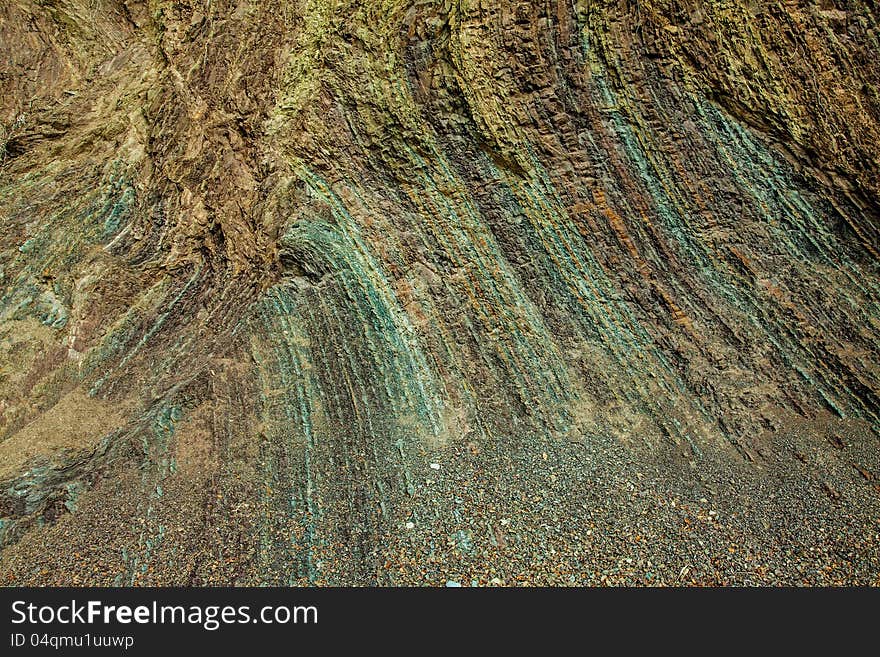 Layered rock texture of a cliff shore with many colors for individual layers. Layered rock texture of a cliff shore with many colors for individual layers