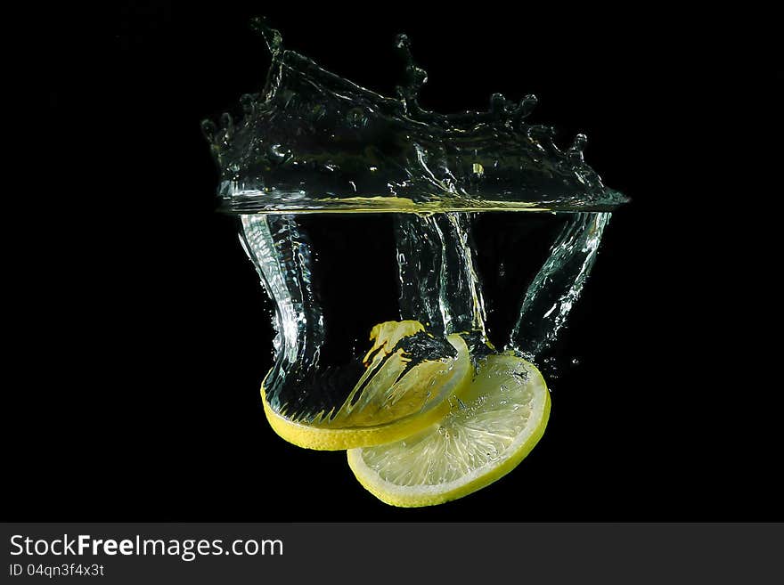 Picture of a fruit - sliced lemon dropped under water. Picture of a fruit - sliced lemon dropped under water