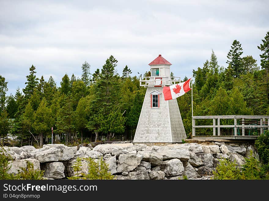 Built in 1898, the South Baymouth range lights rest along a shore reinforced with a low stone wall along the water's edge plus a second, taller wall a few yards back. The lights are nearly identical: white, wood towers angling upward to support square, wooden walkways and lanterns with red caps. Both are marked with a long, red stripe running nearly the height of their front walls to provide day m. Built in 1898, the South Baymouth range lights rest along a shore reinforced with a low stone wall along the water's edge plus a second, taller wall a few yards back. The lights are nearly identical: white, wood towers angling upward to support square, wooden walkways and lanterns with red caps. Both are marked with a long, red stripe running nearly the height of their front walls to provide day m