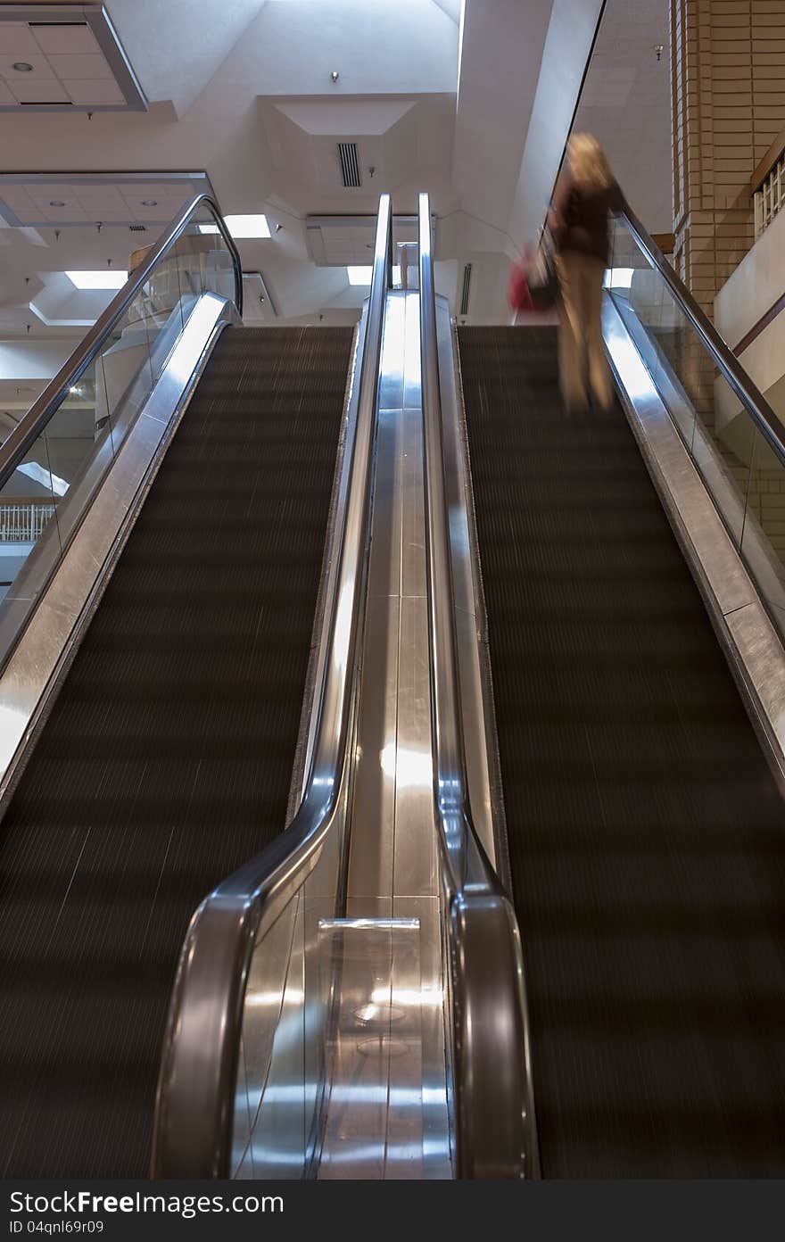 Dual escalators with steps blurred by motion inside a shopping mall. Dual escalators with steps blurred by motion inside a shopping mall.