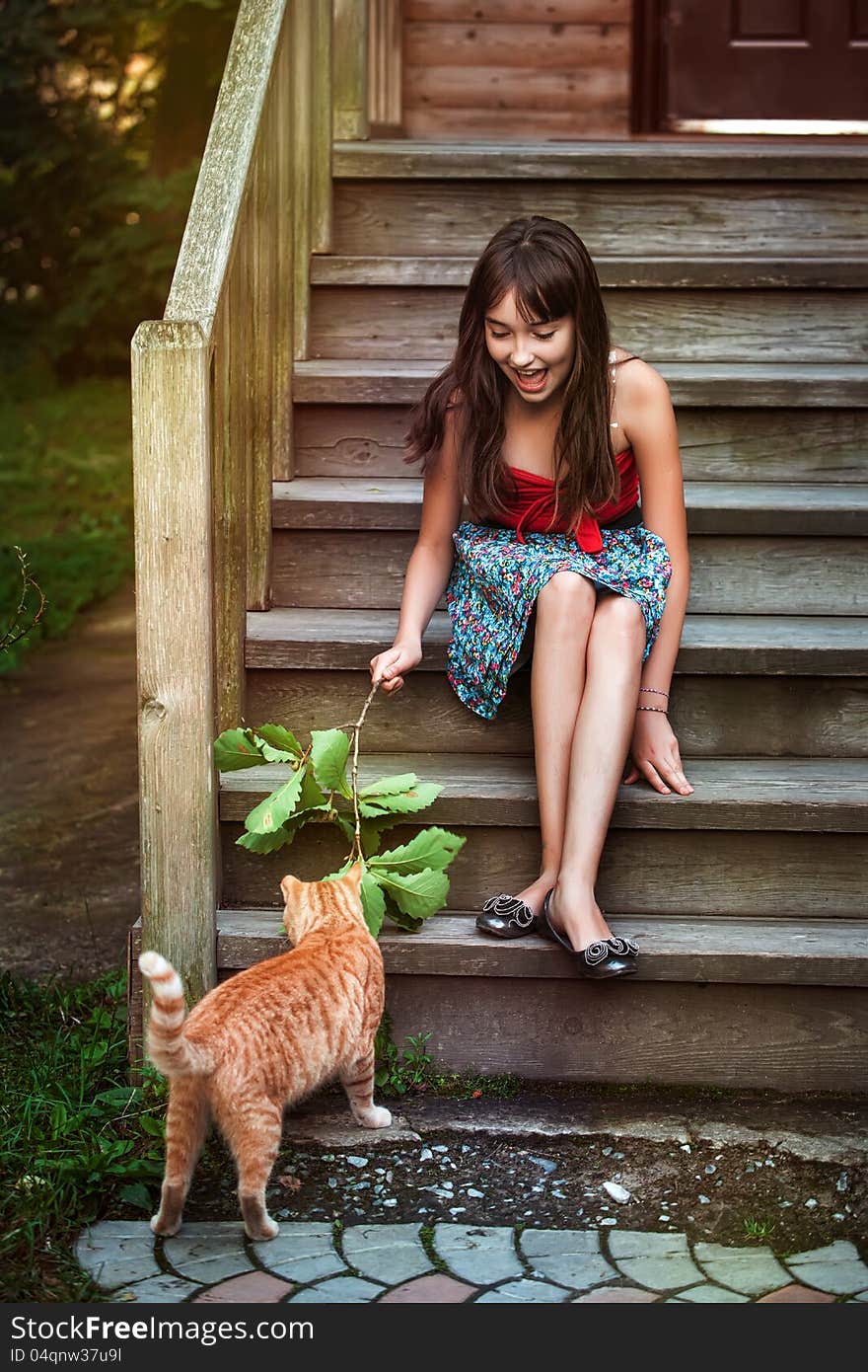 Girl in red dress playing with cat. Girl in red dress playing with cat