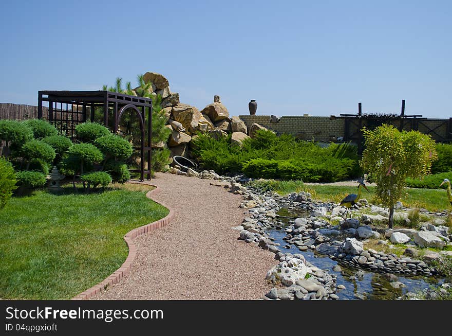 Peaceful park in the summer with an arbor and a stream. Peaceful park in the summer with an arbor and a stream