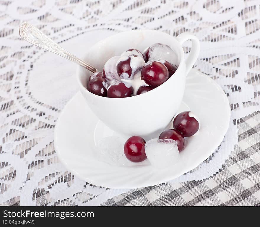 White cup with cherries ,cream and ice. White cup with cherries ,cream and ice