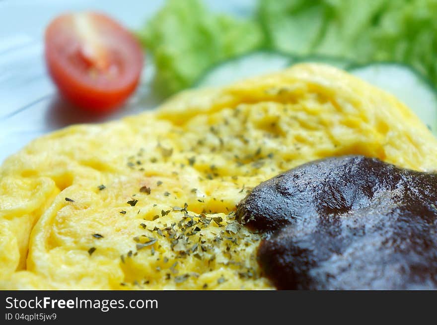 Scrambled eggs with blackpepper sauce and slice of tomato