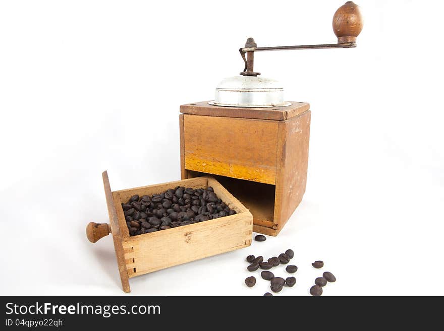 An old coffee grinder with coffee beans.