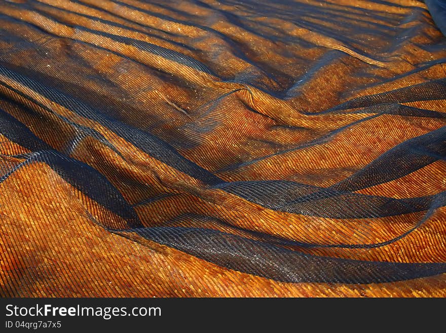 Black Netting covering an orange artificial turf. Black Netting covering an orange artificial turf