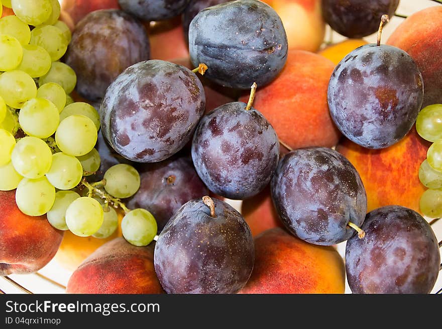 Mix of autumn fruits, close-up:grapes,plums,apple,peach