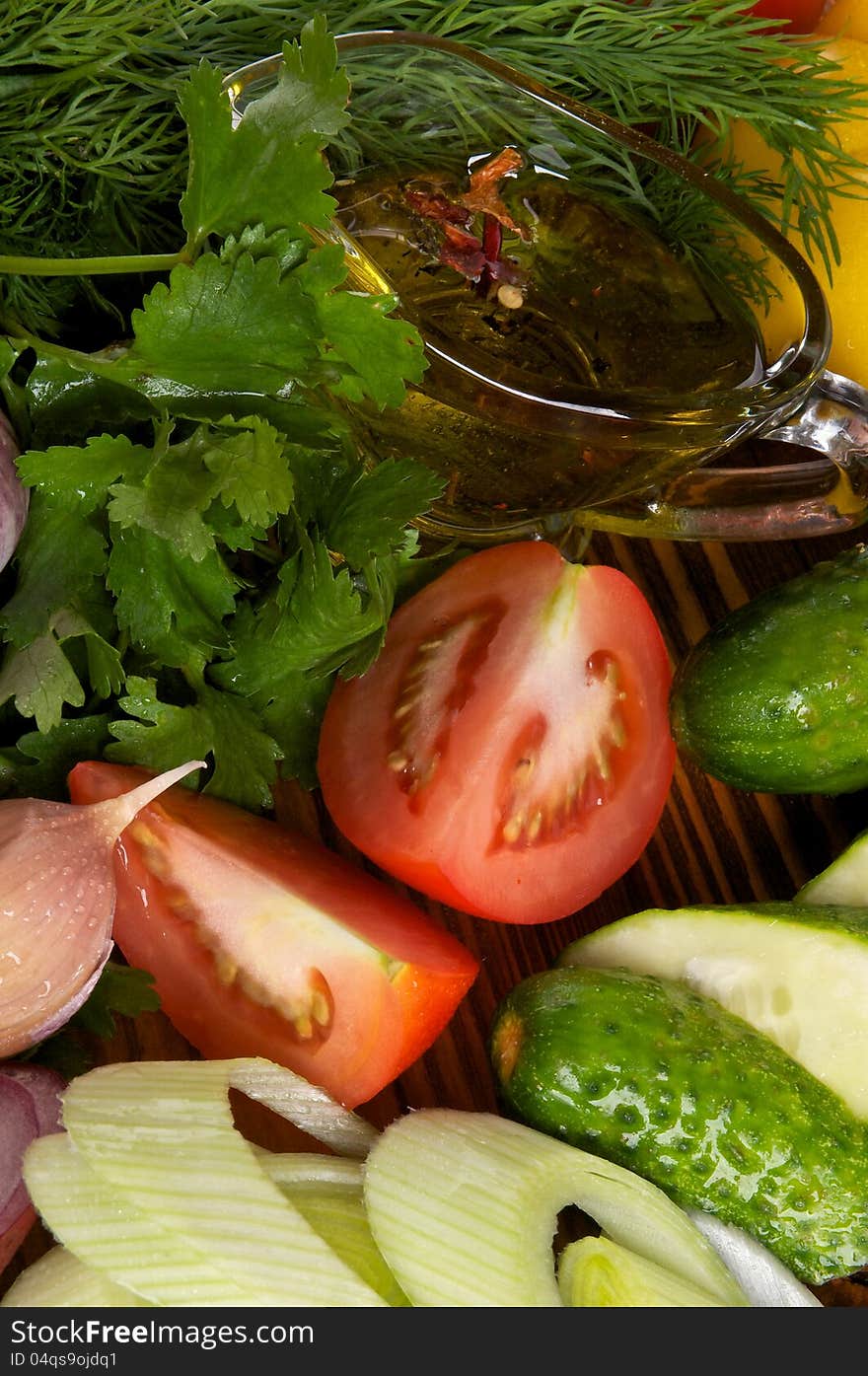 Arrangement of Vegetable Salad Ingredients with Tomatoes, Cucumber, Garlic, Parsley, Leek and Olive Oil close up. Arrangement of Vegetable Salad Ingredients with Tomatoes, Cucumber, Garlic, Parsley, Leek and Olive Oil close up