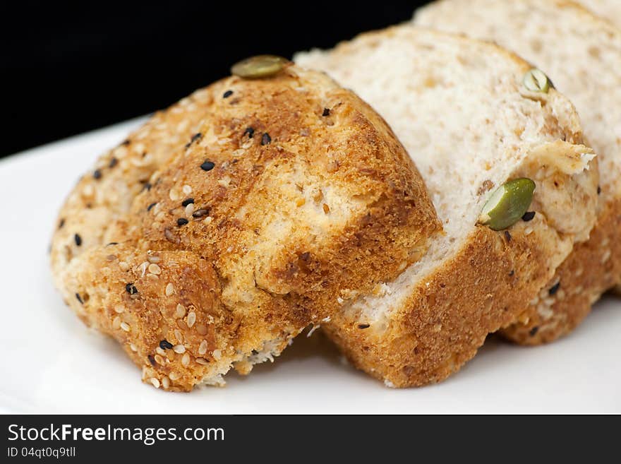 Fresh wholewheat bread with sunflower seeds Sesame and slices on black background. Fresh wholewheat bread with sunflower seeds Sesame and slices on black background