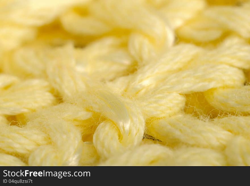 A super macro shot of yellow knitted fabric. A super macro shot of yellow knitted fabric