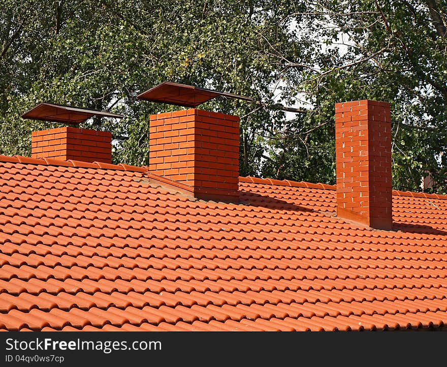 The roof is covered with orange tiles and chimneys