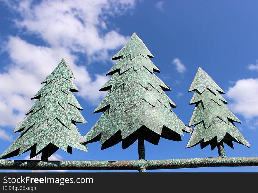 Metal pine trees against bright blue sky