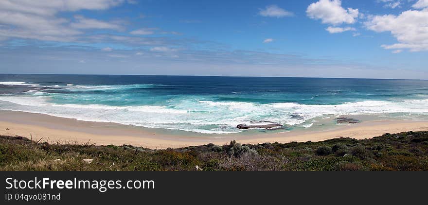 The dark blue waters of the Indian Ocean roll in with huge surfing waves onto Yallingup beach in south western Australia which is a world famous surfing location all year round. The dark blue waters of the Indian Ocean roll in with huge surfing waves onto Yallingup beach in south western Australia which is a world famous surfing location all year round.