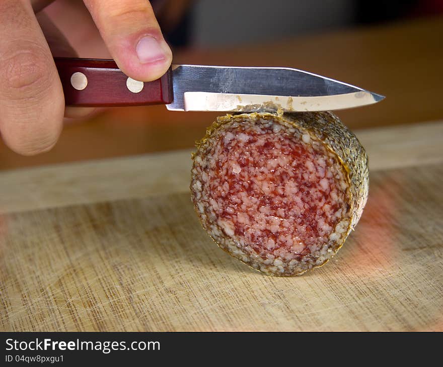 Cutting salami on a wooden board