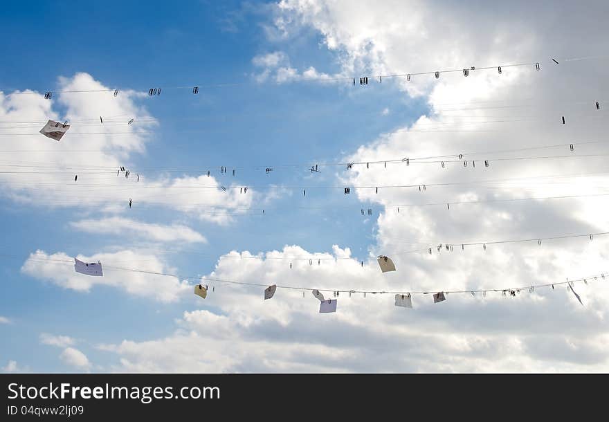 Against the background of the blue sky cloud visible fishing line hanging from her clips and notes. This symbolizes instolyatsiya thoughts and ideas come to mind of man. Against the background of the blue sky cloud visible fishing line hanging from her clips and notes. This symbolizes instolyatsiya thoughts and ideas come to mind of man.