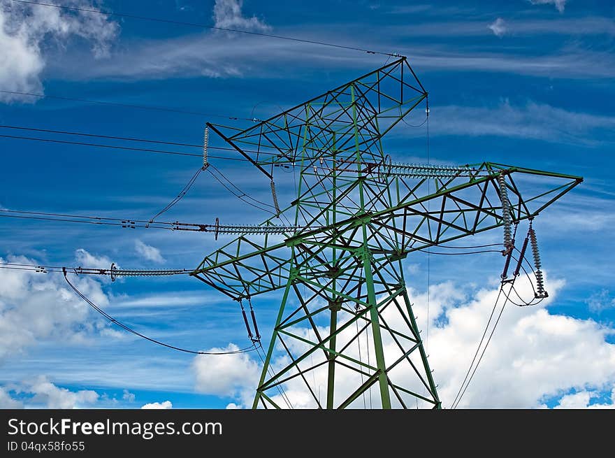 Electric support with wires and insulators against the cloudy sky