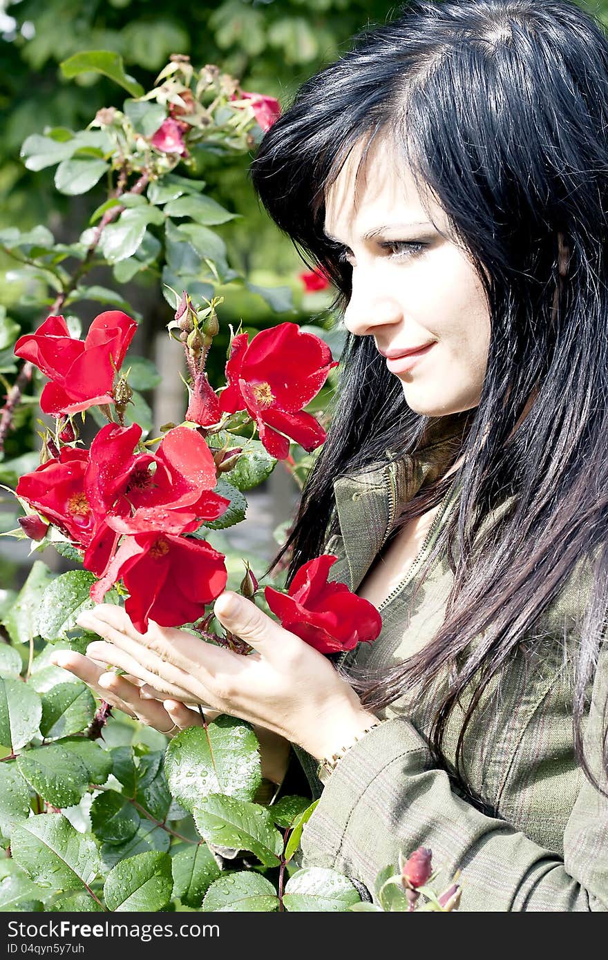 Beautiful brunette near red roses