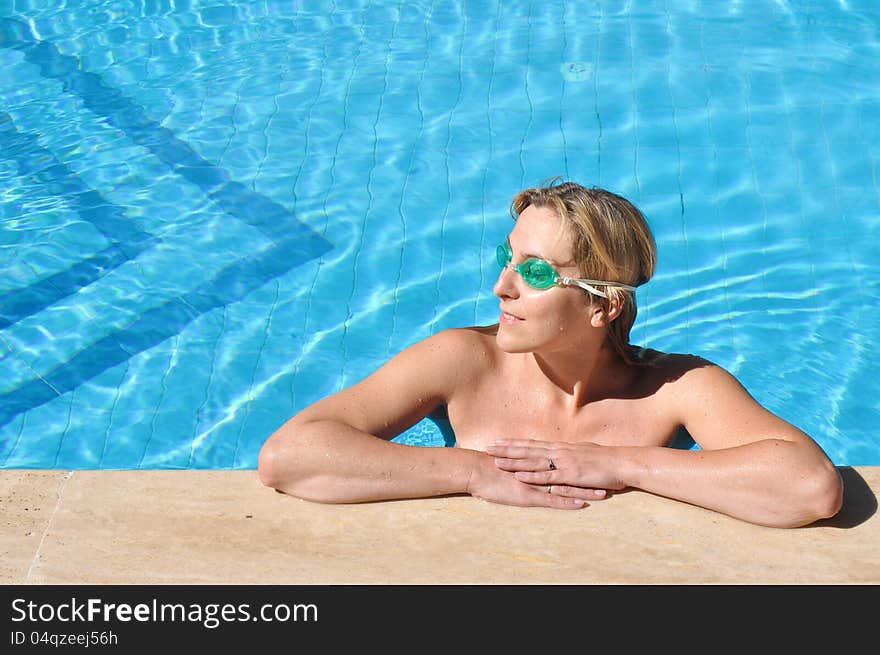 Beautiful girl in a swimming pool, wearing a swimming goggles