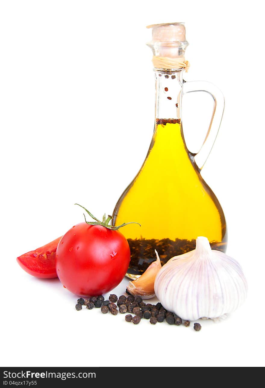 A bottle of  olive oil with  garlic, tomatoes and peppers.