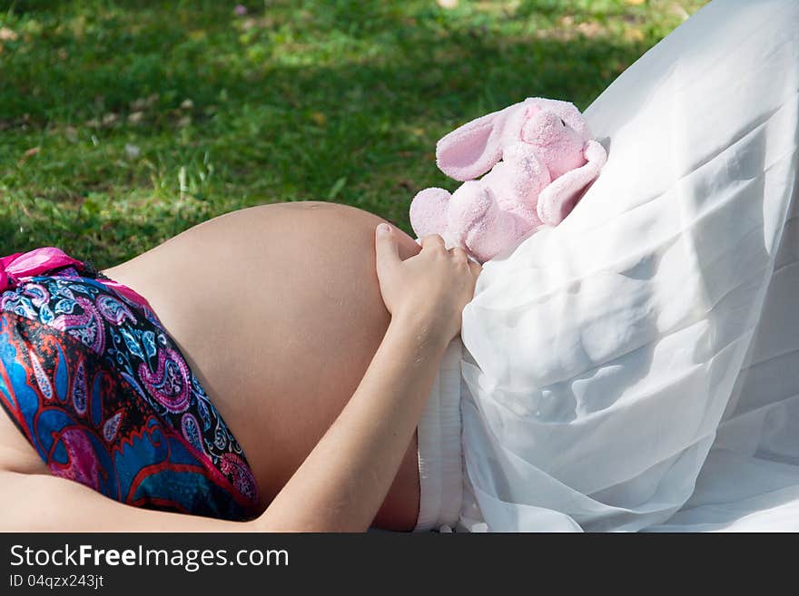 Prengnat woman caressing her huge belly at open air. Prengnat woman caressing her huge belly at open air