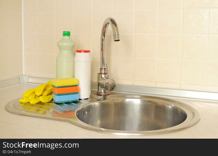 Detergent bottles and sponges near the faucet in the kitchen