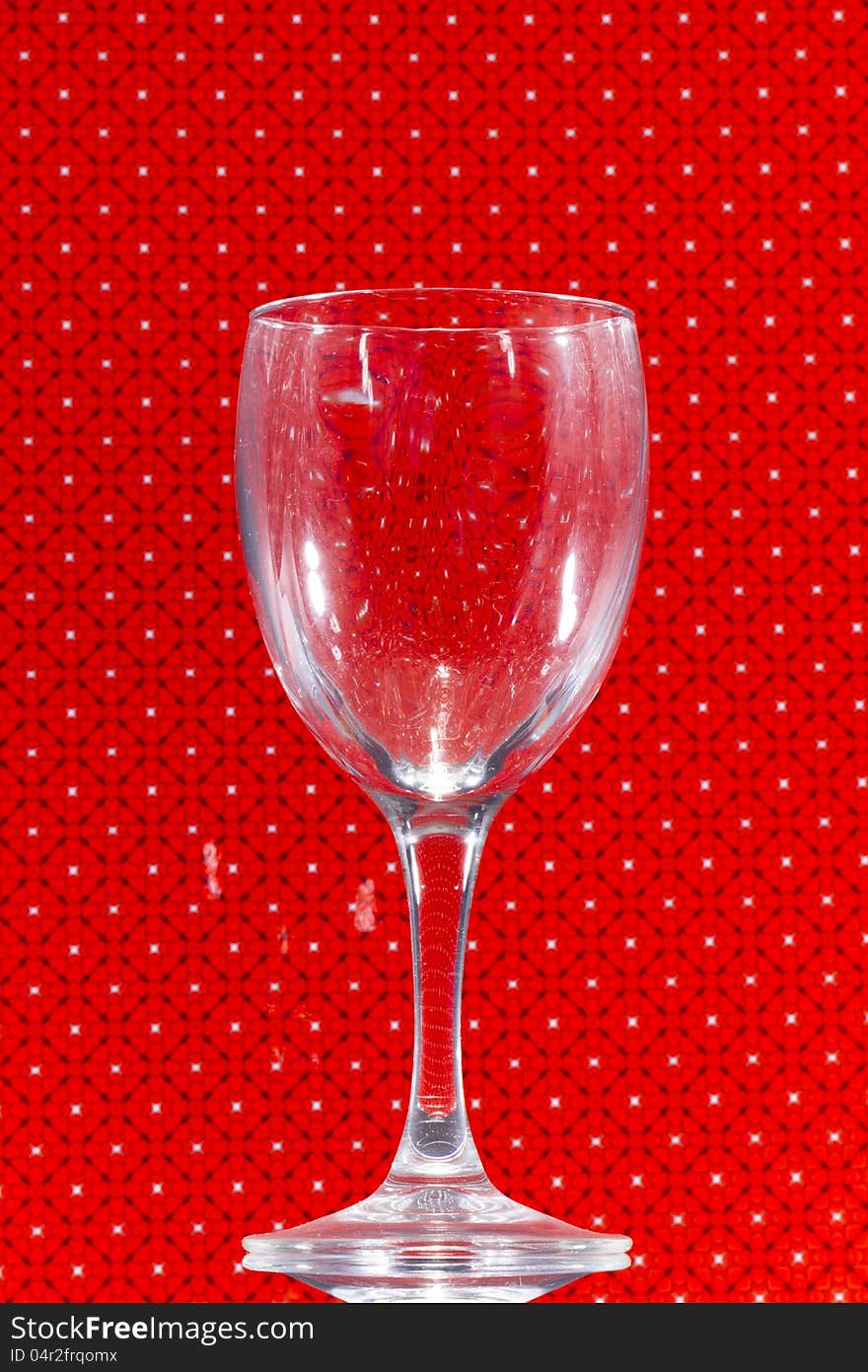 Close up view of transparent glass over a red background. Close up view of transparent glass over a red background.