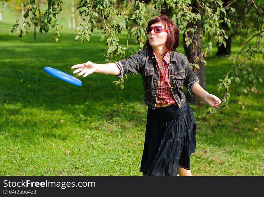 Young woman having fun with frisbee in the parkin sunny summer day. Young woman having fun with frisbee in the parkin sunny summer day.